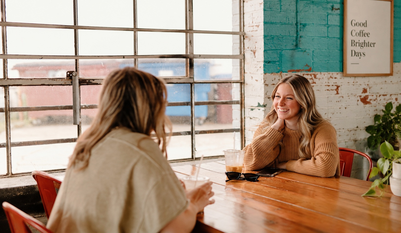 Two friends talking over coffee at a cafe table
